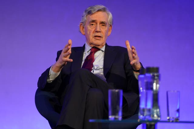 Gordon Brown gestures with his hands as he sits in a chair