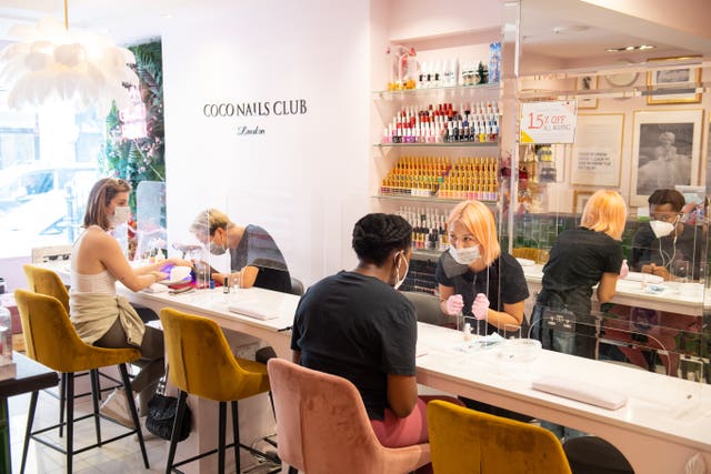 Customers observe social distancing during treatments at Coco Nails Club in London as they reopen to customers on following the easing of lockdown restrictions in England