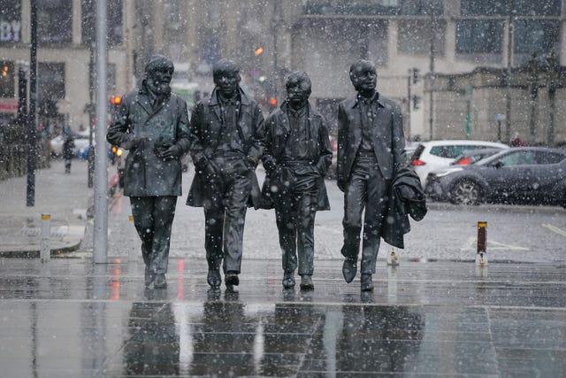 Snow falls around the Beatles statue in Liverpool