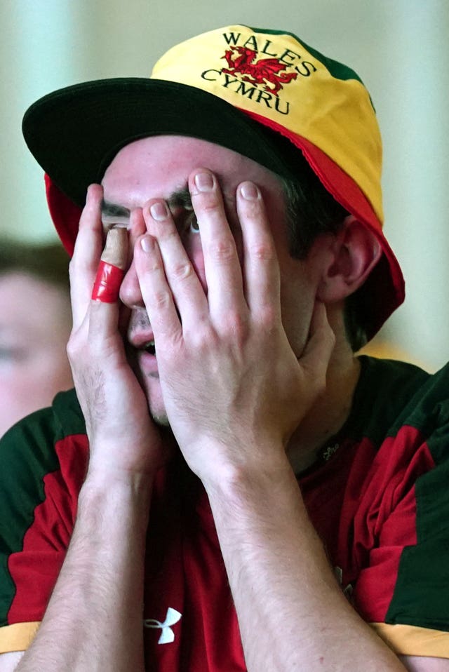 One Wales supporter can't believe the score as he watches the match at the fan park in Swansea (Jacob King/PA)