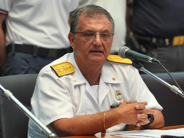 Rear Admiral Raffaele Macauda seated while speaking into a microphone