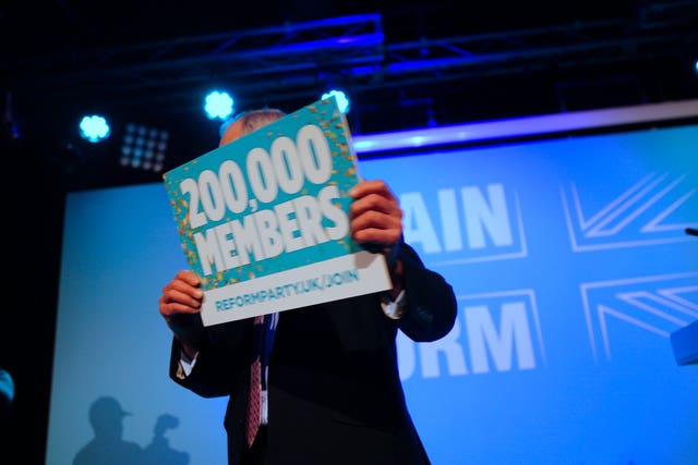 Nigel Farage holds up a sign that says 200,000 members