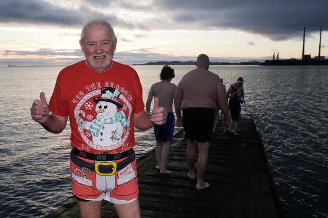 An elderly man in a Christmas outfit