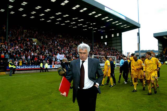 Bobby Gould leads his Cheltenham team off the pitch after a defeat in 2003