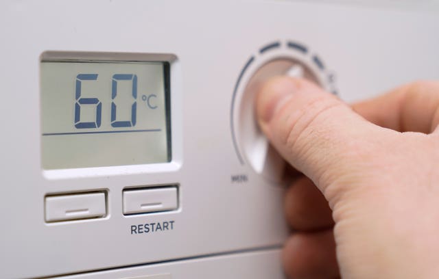 A homeowner turns down the temperature of a gas boiler in Basingstoke, Hampshire