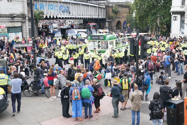 Police and demonstrators with a bus parked on London Bridge (Ian West/PA)