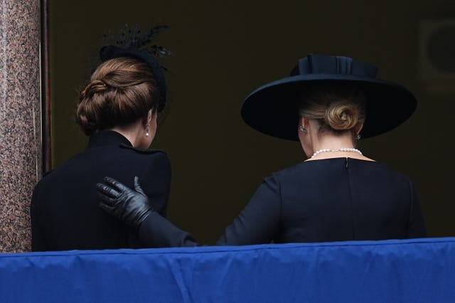 Sophie puts her hand on Kate's back as they leave a balcony overlooking the Remembrance service