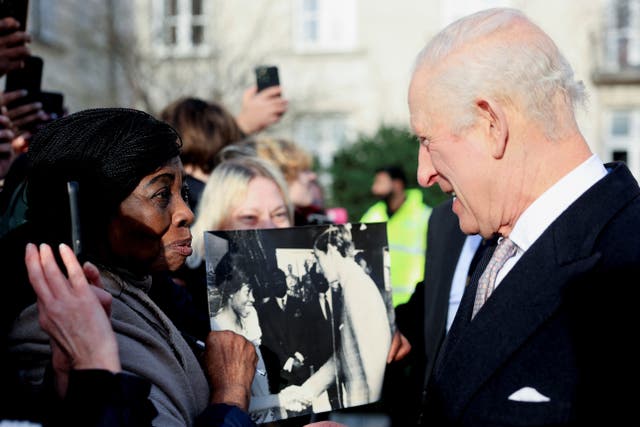 Caroline Akuffo shows the King a photo of them meeting in Japan in 1970