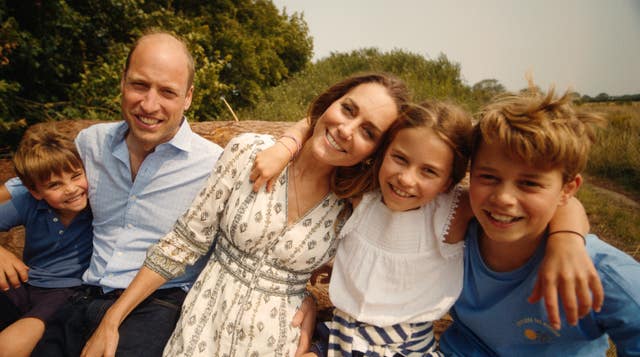 The Wales family posing with their arms around one another