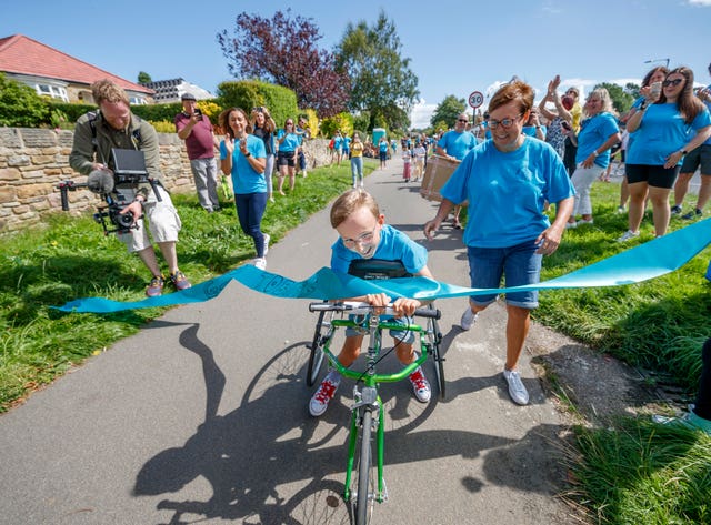 Tobias reaches the end of his challenge to run a marathon in the street near his home in Sheffield using a race runner 