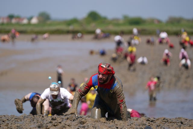 Competitors take part in the annual Maldon Mud Race, a charity event to race across the bed of the River Blackwater in Maldon, Essex