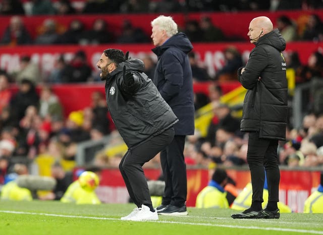 Manchester United manager Ruben Amorim yells at his team with his arms outstretched, with Everton manager David Moyes in the background