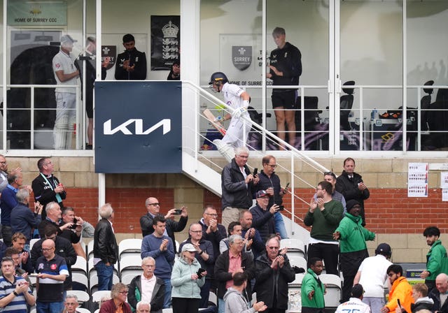 England’s Ollie Pope, top, takes the applause of the crowd as the players head off for bad light