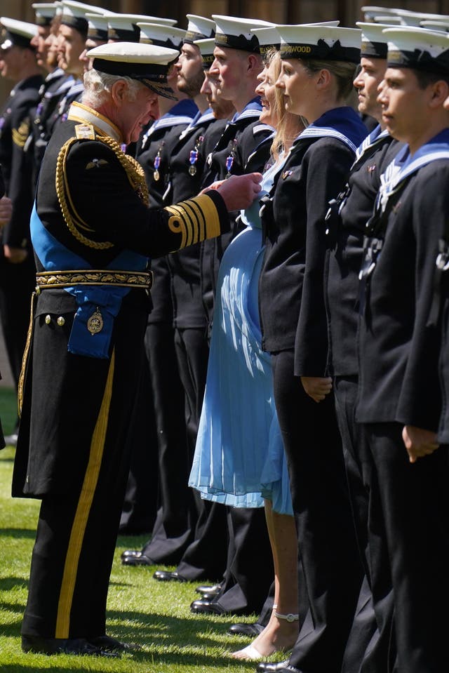 The King presents seven month pregnant  medical assistant Paisley Chambers-Smith with the Royal Victorian Order and to other members of the Royal Navy for their part in Queen Elizabeth II’s funeral procession, on the Quadrangle at Windsor Castle