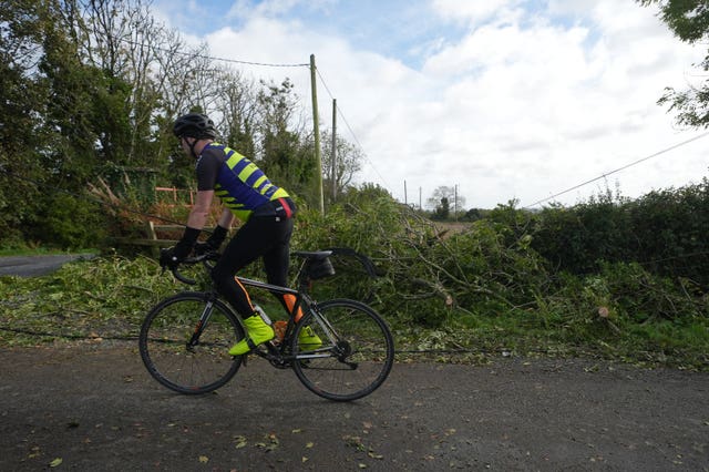 A cyclist passes fallen branches a a power cable in Balbriggan, Co Dublin