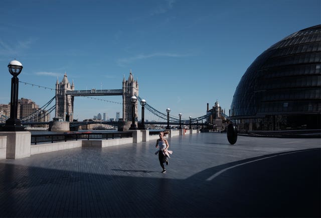 A woman jogs near City Hall in central London 