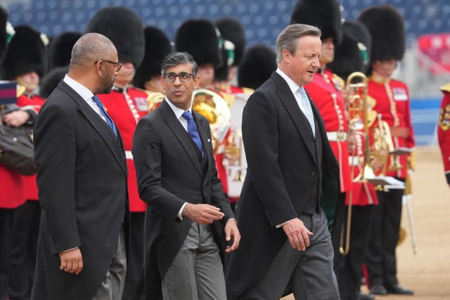Home Secretary James Cleverly, Prime Minister Rishi Sunak and Foreign Secretary Lord David Cameron chat near soldiers at Horse Guards Parade