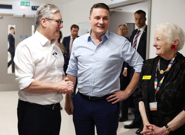 Sir Keir Starmer, left, and Wes Streeting with their shirt sleeves rolled up while on a hospital ward