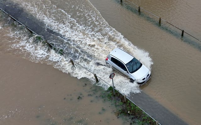 A car passes through flood waters in Yalding, Kent