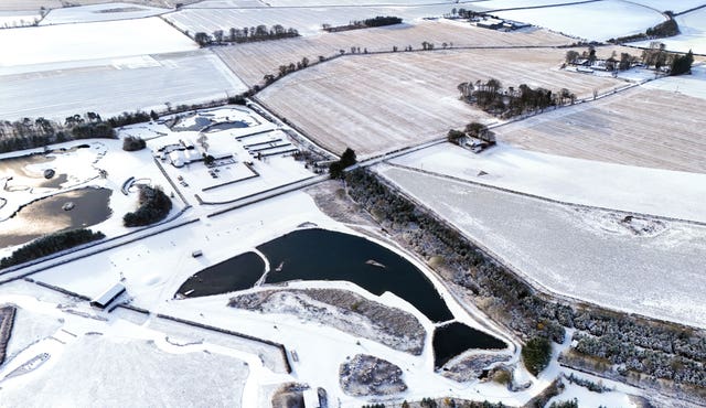 The man-made fish-shaped Muckle Troot Loch near Inverurie, Aberdeenshire, surrounded by snow and ice as temperatures dropped in November