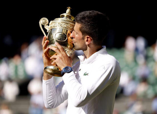 Djokovic kisses the Wimbledon trophy after last year's win over Nick Kyrgios