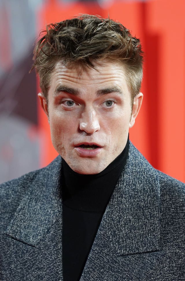 Robert Pattinson in a grey jacket with a black top