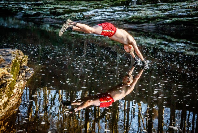 Les Peebles dives into the River Ribble near Stainforth in North Yorkshire