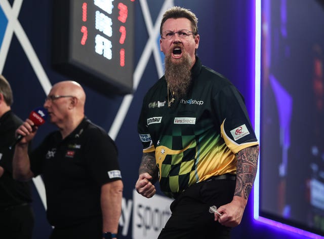 Australian Simon Whitlock celebrates after winning a match at the PDC World Championship