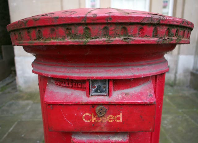 An old red Royal Mail pillar box with a closed sign on it