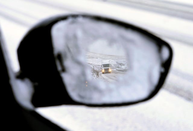 A view from a car wing mirror of a vehicle navigating fresh snow fall on A628 at Woodhead pass. Danny Lawson/PA Wire