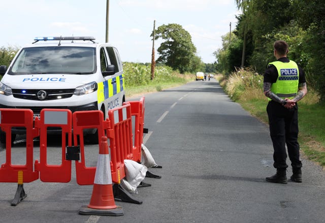 Emergency service vehicles and a police officer at the scene of a light aircraft incident in North Yorkshire