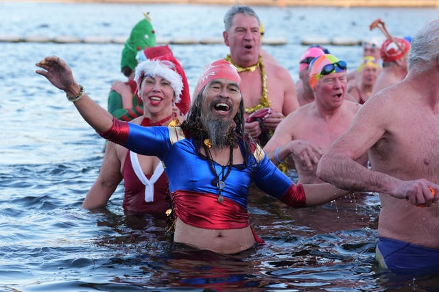 People in festive fancy dress frolicing in the cold water