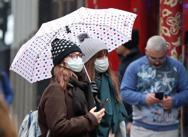 Two women wear face masks on Gerrard Street in Soho, London