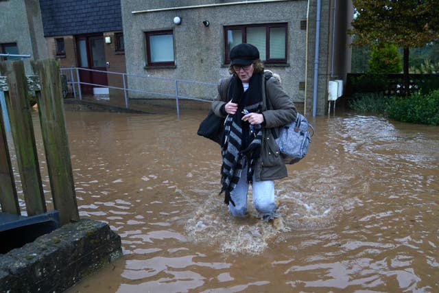 A woman walks through flood water in Brechin, Scotland