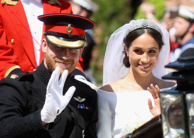 The Sussexes ride in an open-topped carriage through Windsor Castle after their wedding