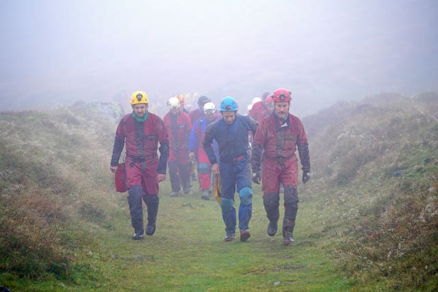 Rescuers walk towards the Ogof Ffynnon Ddu cave system near Penwyllt, Powys in the Brecon Beacons, Wales