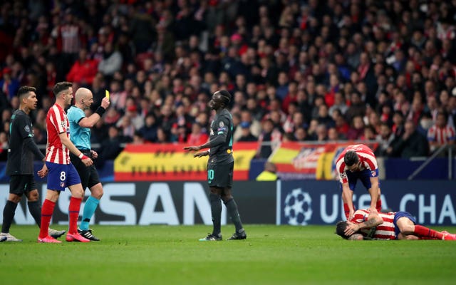 Sadio Mane, centre, is booked for a foul on Atletico Madrid's Sime Vrsaljko, bottom right