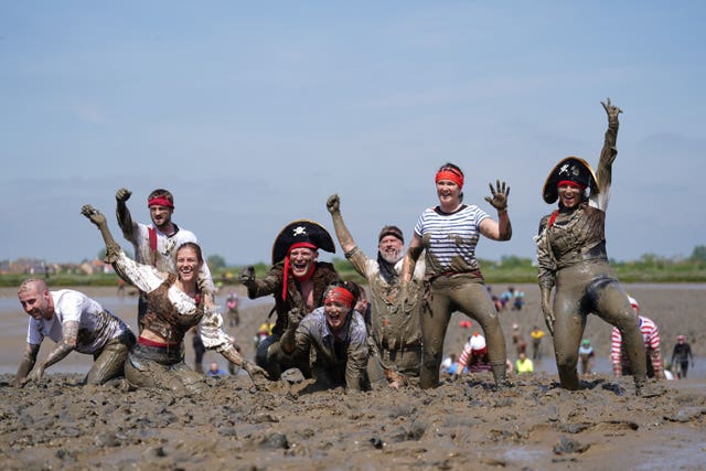 Competitors take part in the annual Maldon Mud Race, a charity event to race across the bed of the River Blackwater in Maldon, Essex