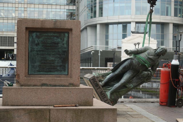 Workers prepare to take down a statue of slave owner Robert Milligan at West India Quay, east London as Labour councils across England and Wales will begin reviewing monuments and statues in their towns and cities 