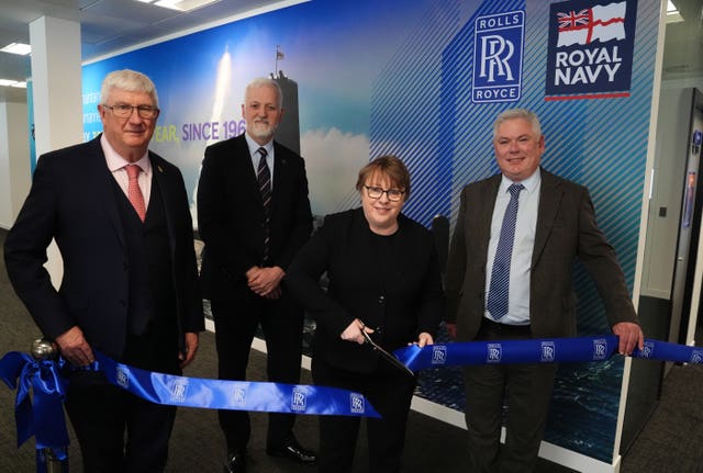 Maria Eagle cuts ribbon alongside three men