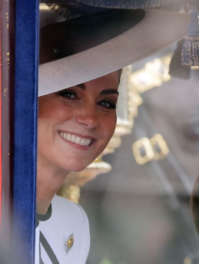 The Princess of Wales smiles at the crowd as she travels along The Mall to the Trooping the Colour ceremony 