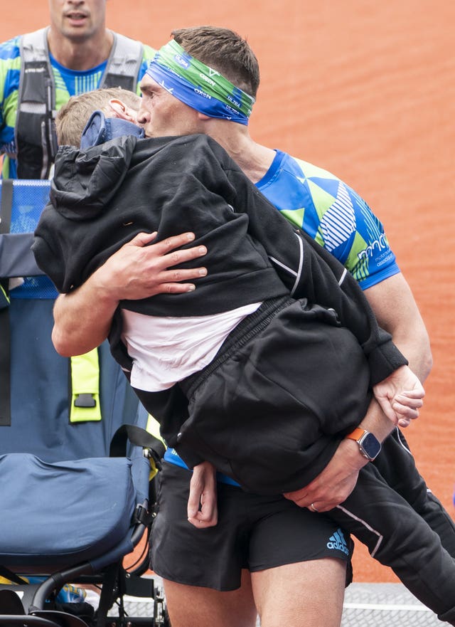Kevin Sinfield kisses Rob Burrow as he carries him across the finish line at the Rob Burrow Leeds Marathon