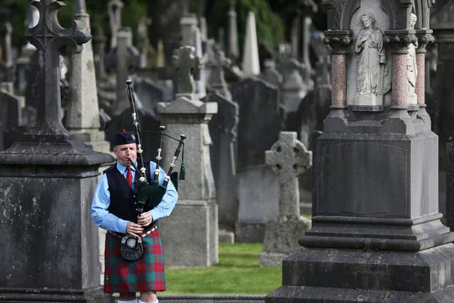 A member of the Black Raven pipe band plays in Glasnevin cemetery