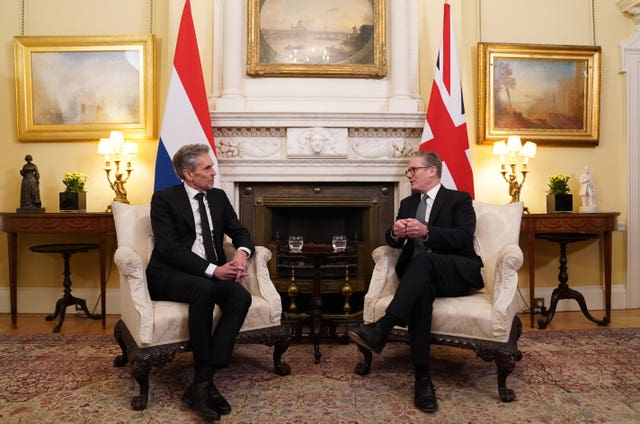 Netherlands Prime Minister Dick Schoof, left, talks to Sir Keir Starmer, both seated in front of a fireplace in 10 Downing Street with a Dutch flag and a Union flag behind them