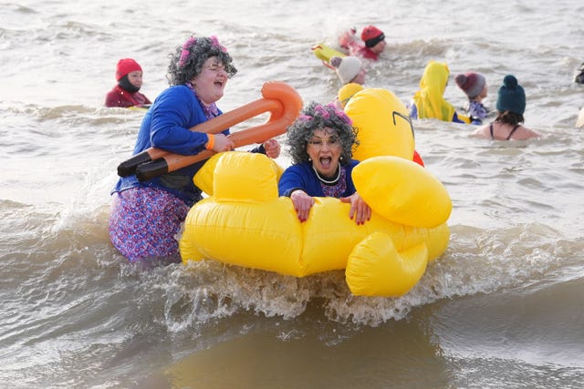 Two women take part in the Southend RNLI New Year Day Dip in an inflatable duck in Southend-on-Sea, Essex