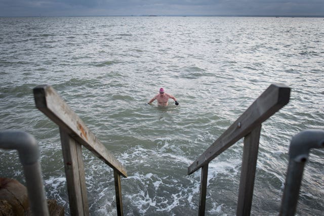 Swimmers take their daily dip in the Thames estuary at Leigh-on Sea in Essex