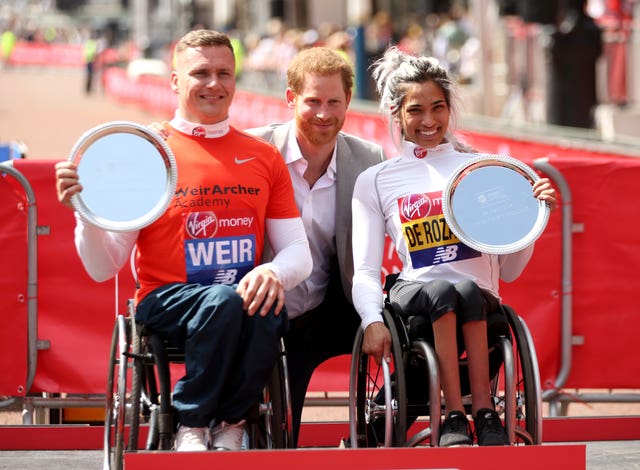 David Weir, left, and Australia’s Madison de Rozario pose with their trophies and Prince Harry after the marathon (Paul Harding/PA)