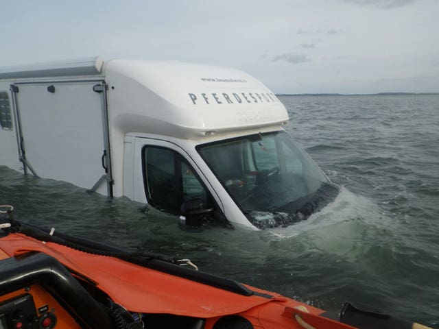 A horsebox type campervan partially submerged on Holy Island causeway 