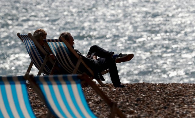 A couple enjoy the autumn sunshine on the beach in Brighton 