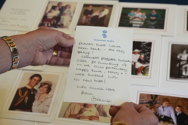 Hands holding a letter in front of a photo album